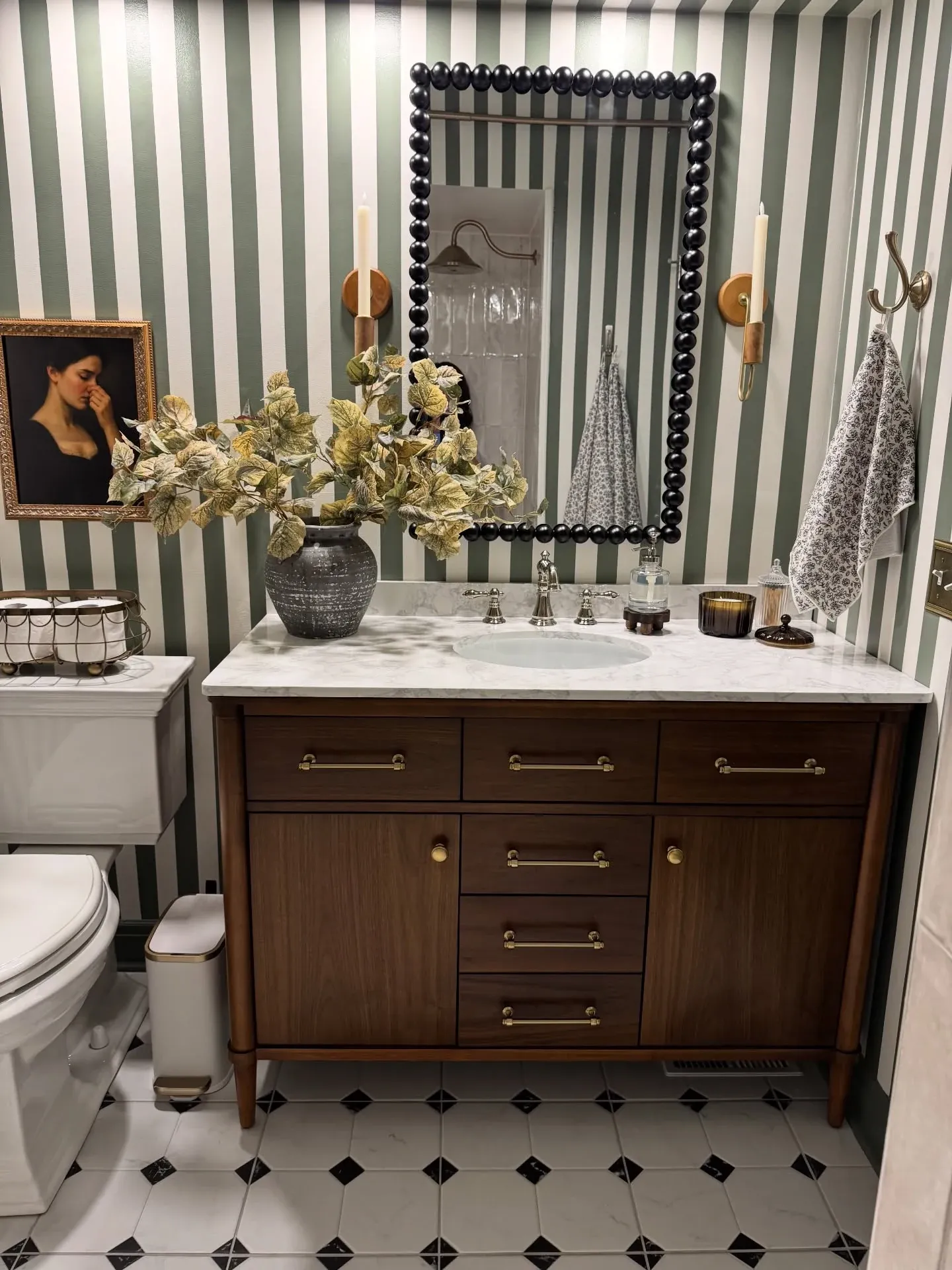 modern fun bathroom with green striped wallpaper black mirror and dark wood vanity
