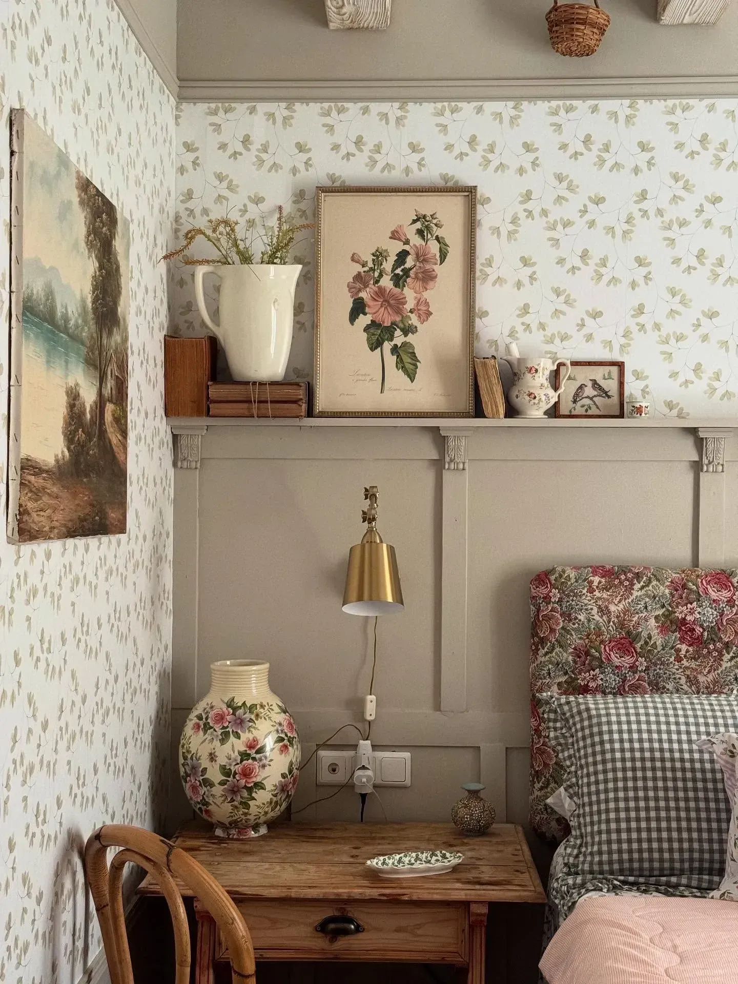 vintage home decor ideas for bedroom with floral wallpaper, vintage artwork, floral headboard, and wooden nightstand