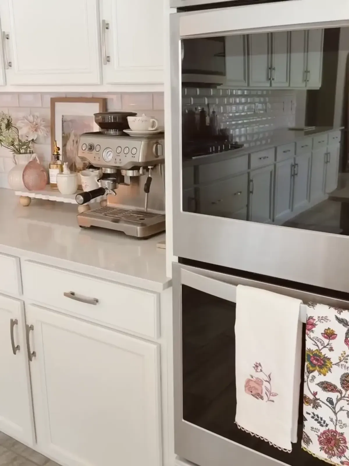 coffee station ideas with espresso machine, white tray, syrup bottle, mug, flowers, and framed art