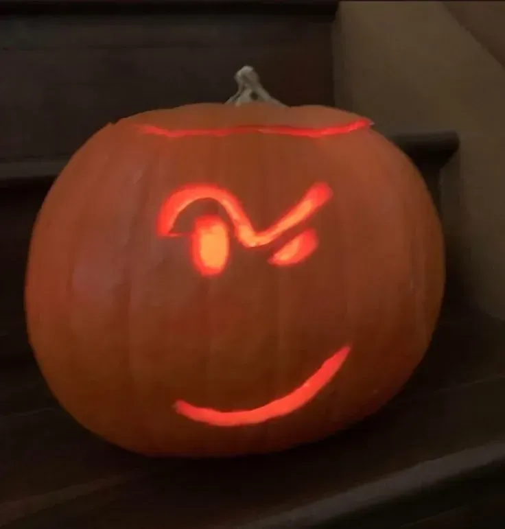 kid friendly pumpkin carving ideas with simple wink face, glowing curved eye, and easy smile carving